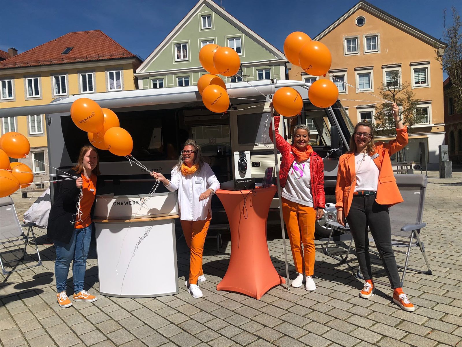 Team mit Ballons auf dem Marktplatz